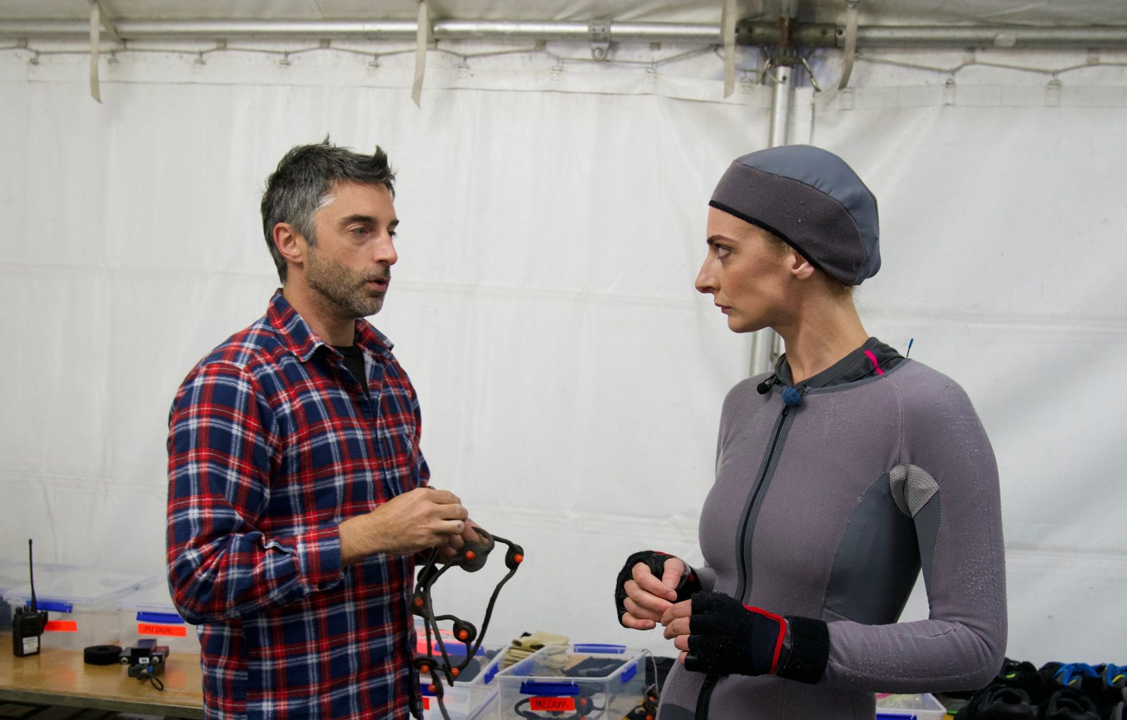A crew member fits motion-capture gear on Emily Riedel