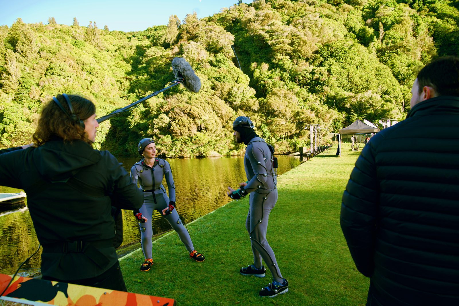 Crew shooting a motion-capture performer outdoors on a lawn