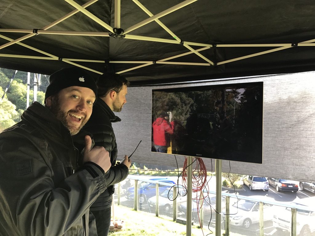 Dan Lemmon giving a thumbs up under the monitor tent, with John