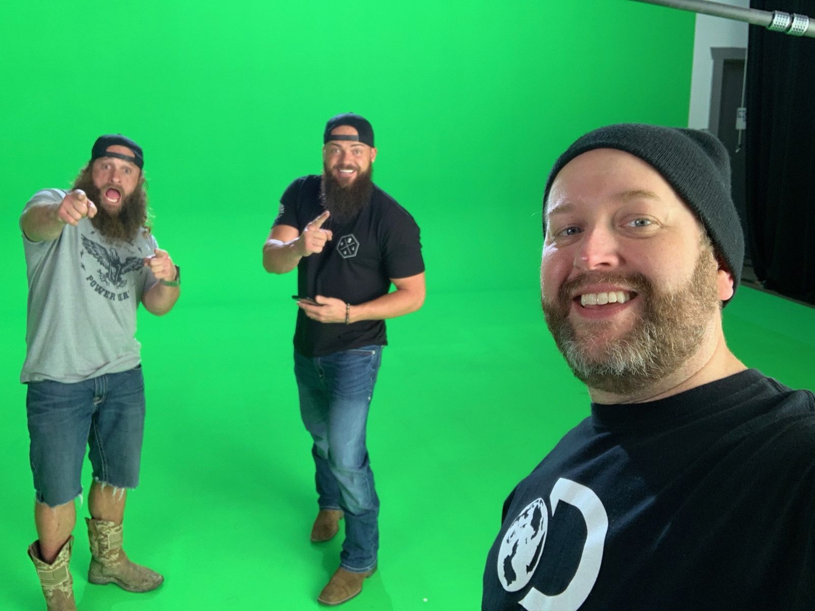 Heavy D and Diesel Dave on green screen behind a smiling crew member taking a selfie
