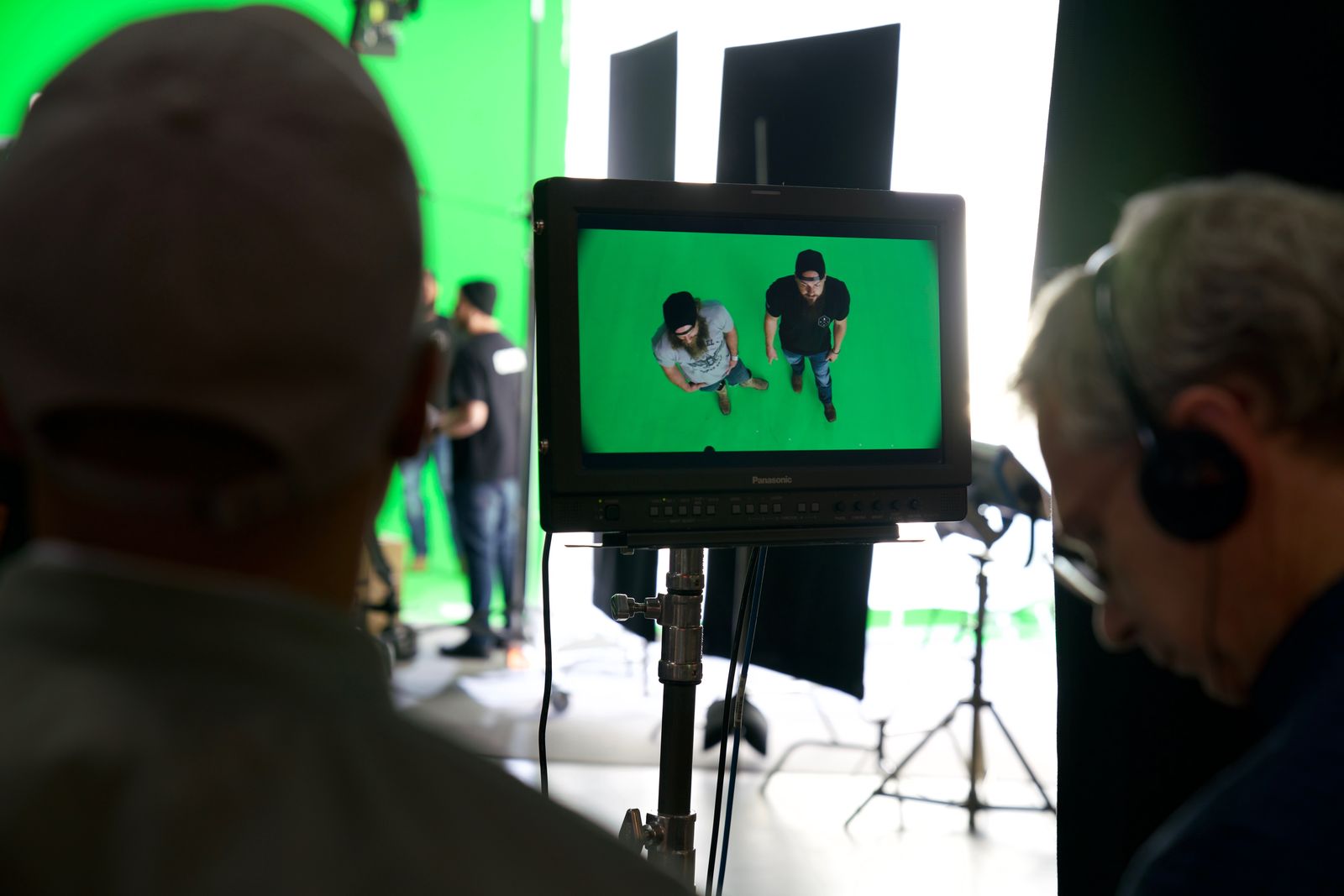 A monitor showing a top-down shot of the two talent on green screen