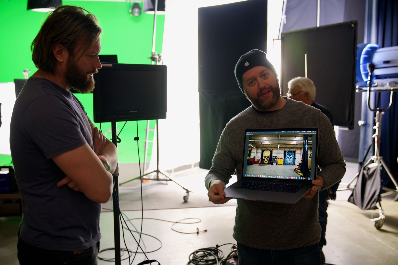 A crew member holds a laptop on stage to review a shot