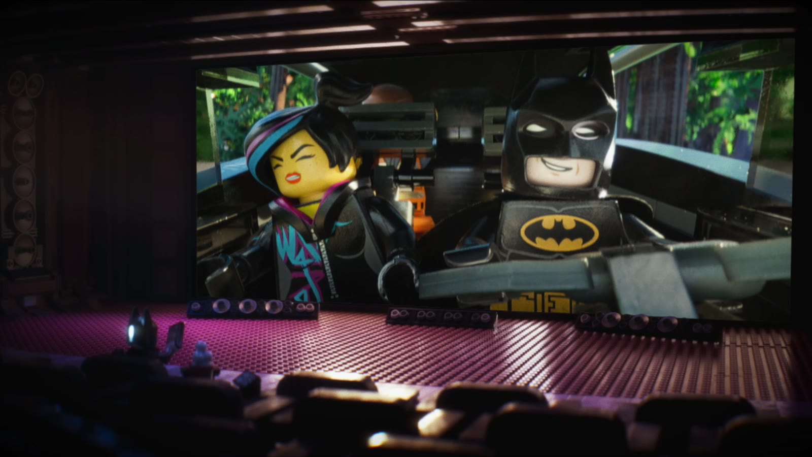 Lego Batman in a movie theater watching The LEGO Movie on the big screen